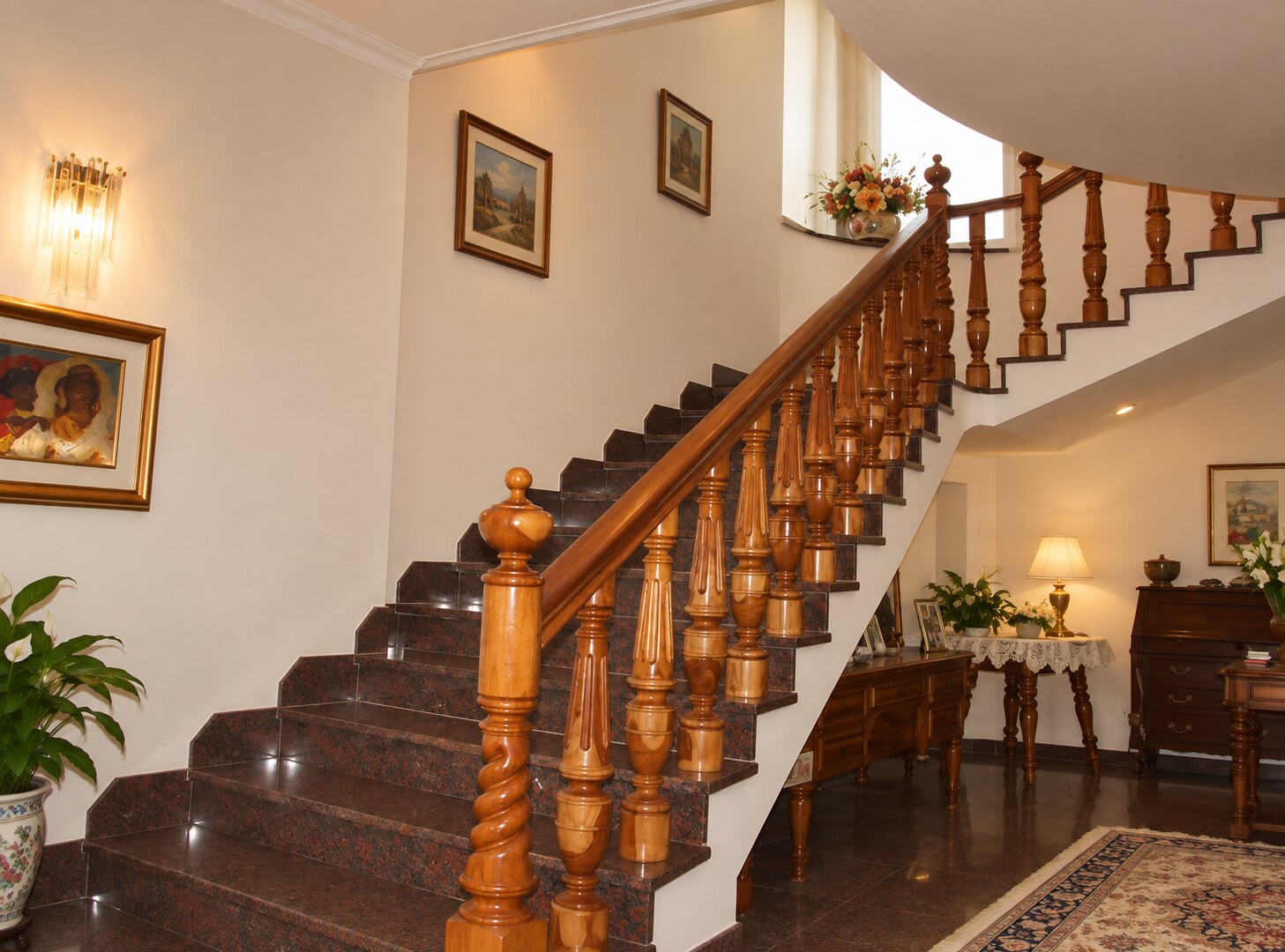 Escalera interior con peldaños de piedra, pasamanos y balaustres torneados